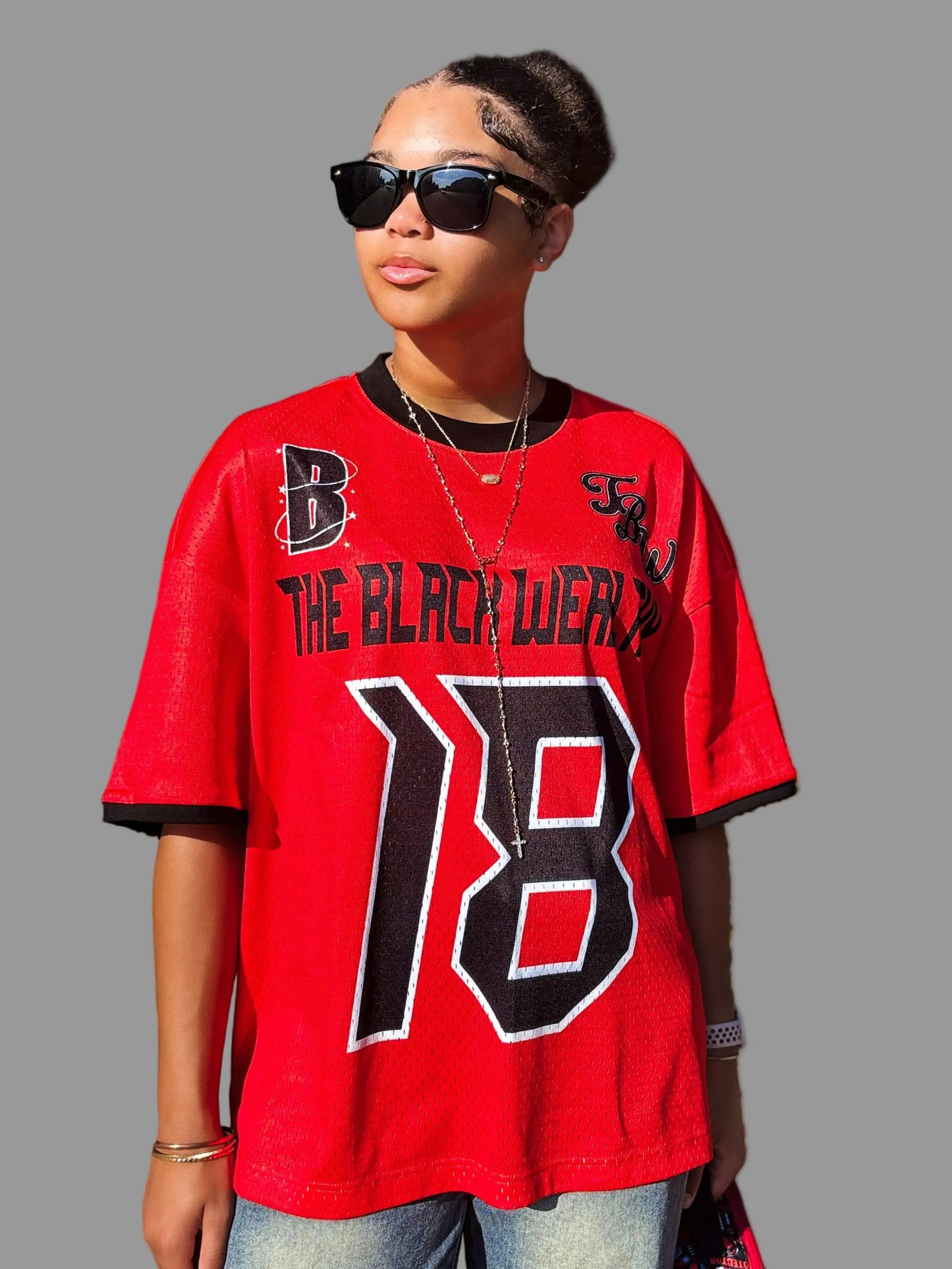 Person wearing a red jersey with text and number, standing outdoors.