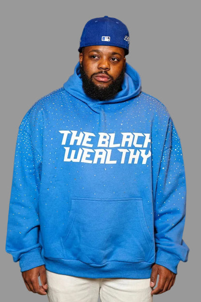 Man wearing a blue hoodie with 'The Black Wealthy' text and a matching cap against a dark background.