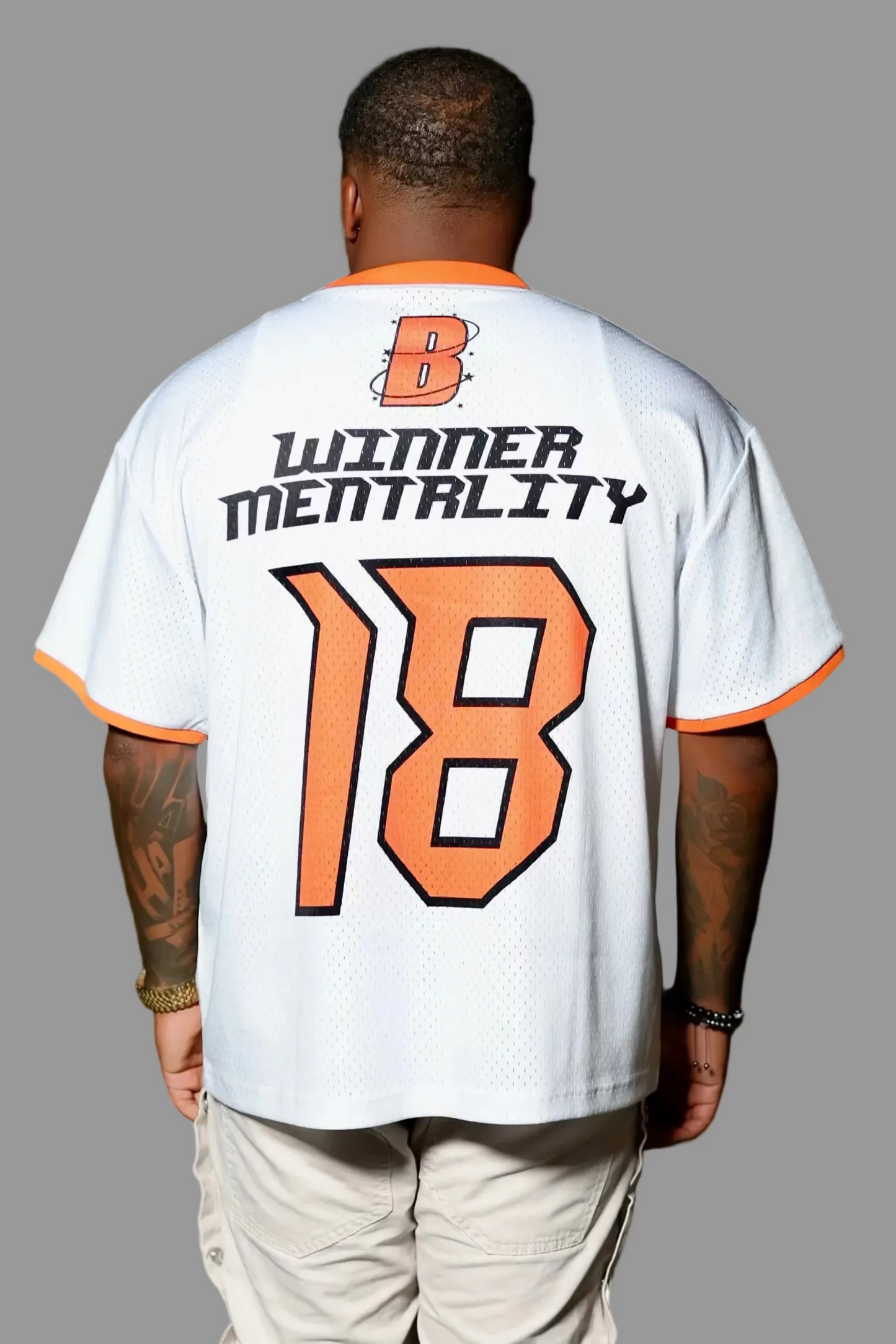 Person wearing a white jersey with text and number '18' outdoors at night.