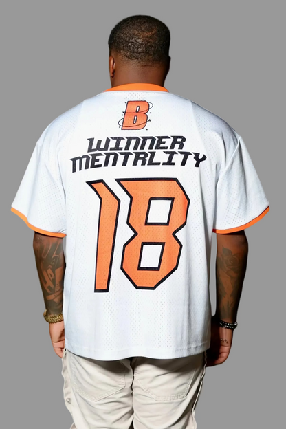 Person wearing a white jersey with text and number '18' outdoors at night.