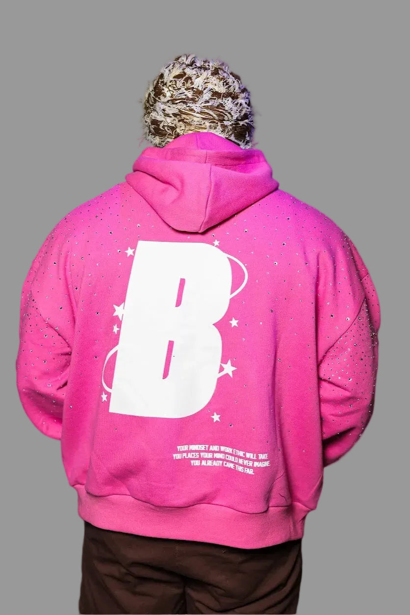 Person wearing a bright pink hoodie with a large white letter 'B' on the back
